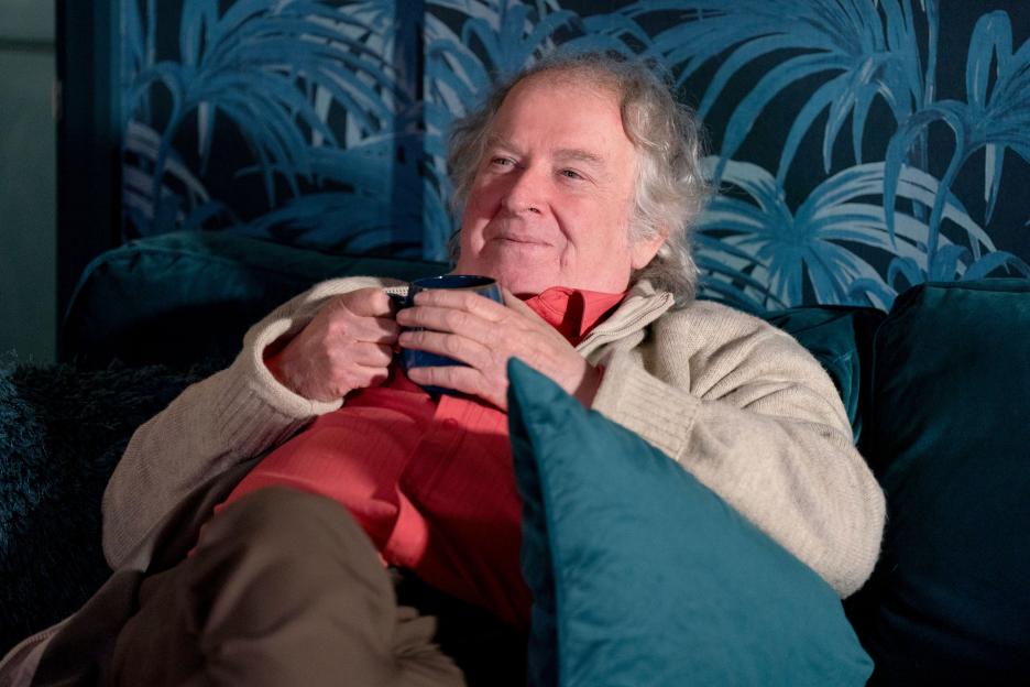 Nigel (Paul Bradley) from EastEnders holding a mug.