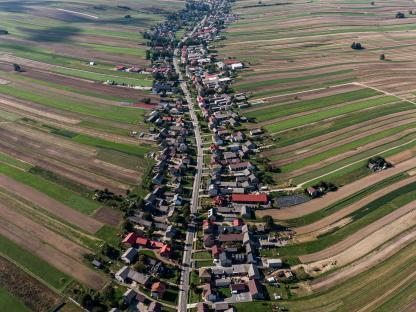 Aerial view of Suloszowa, Poland, a long village surrounded by agricultural fields.