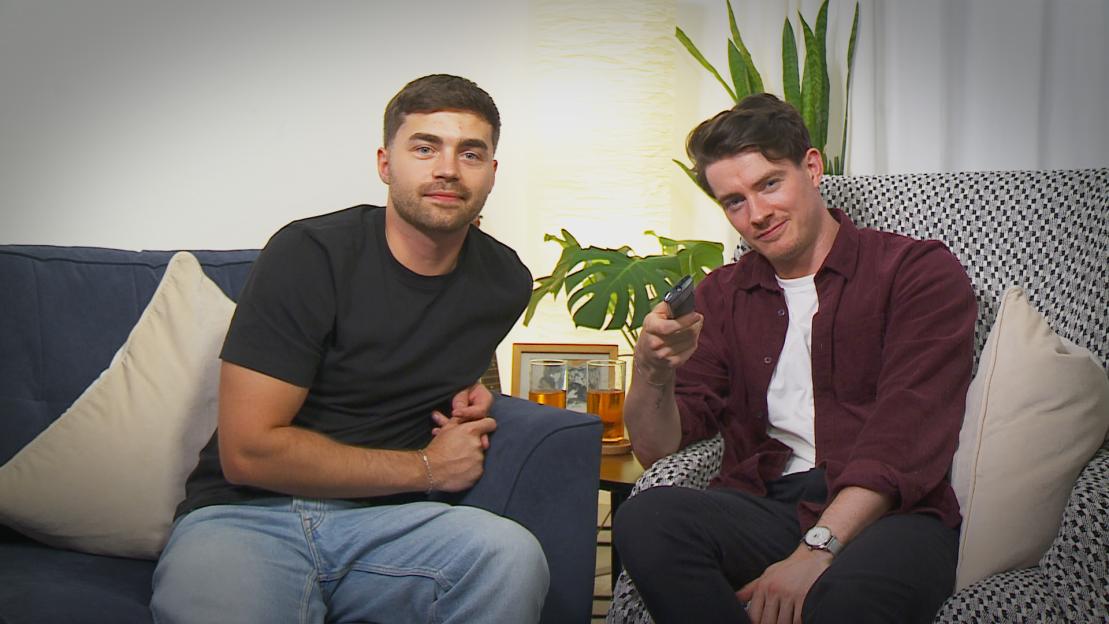 Friends Jake and Calum from Glasgow sitting on couches, with Calum holding a TV remote.