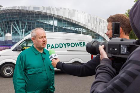 Man in green being interviewed in front of a Paddy Power van.