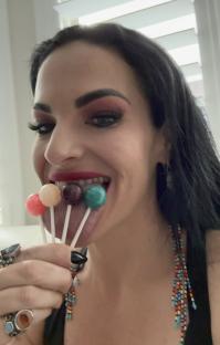 a woman with a ring on her finger is eating lollipops