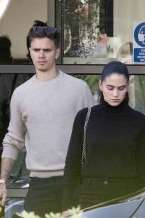 Romeo Beckham and Kim Turnbull arriving at an airport.
