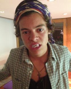 Close-up photo of Harry Styles wearing a bandana and grill.