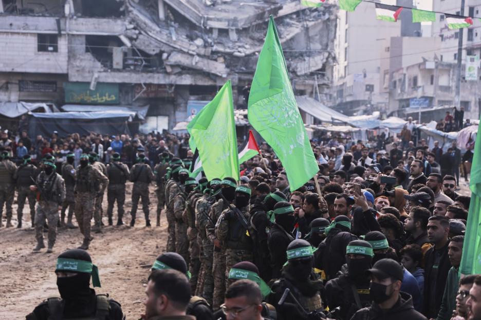Hamas fighters deployed in central Gaza City with green flags, ahead of a planned release of hostages.