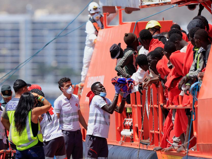 Rescue worker carrying a migrant child off a coast guard vessel.
