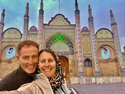 Couple posing for a selfie in front of an ornate building.