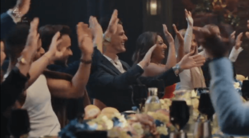 People clapping at a table.