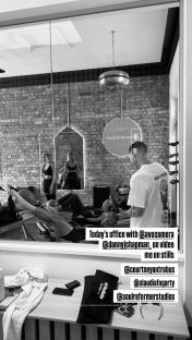 Black and white photo of a Pilates studio, with people exercising and a photographer taking photos.