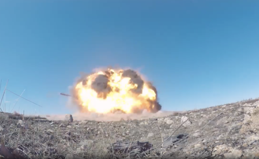 Large explosion in a desert landscape.
