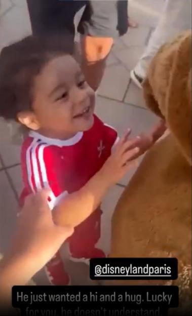 Toddler reaching for a Disneyland Paris mascot.