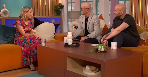Three people sitting on a couch during a talk show.