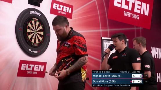Michael Smith at a darts match, looking down.