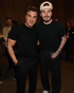 Two men in black shirts and trousers.