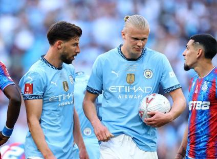 Ruben Dias and Erling Haaland of Manchester City after a penalty is awarded.