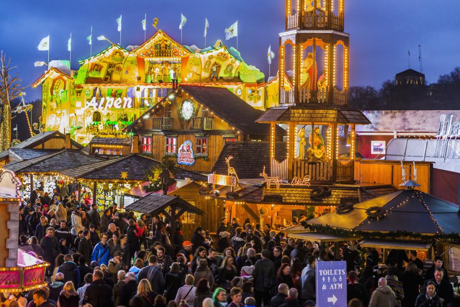 Crowded Christmas market at dusk.