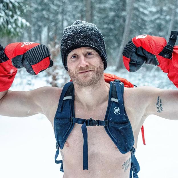 Andre Schürrle flexing in the snow while wearing a hat and gloves.