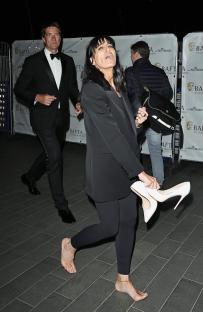 Claudia Winkleman leaving the BAFTA TV awards barefoot, holding her high heels.