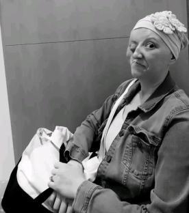Black and white photo of a woman wearing a headscarf, winking at the camera.