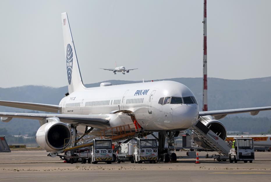 A Pan Am Boeing 757-23N at Marseille Provence Airport with another plane taking off in the background.