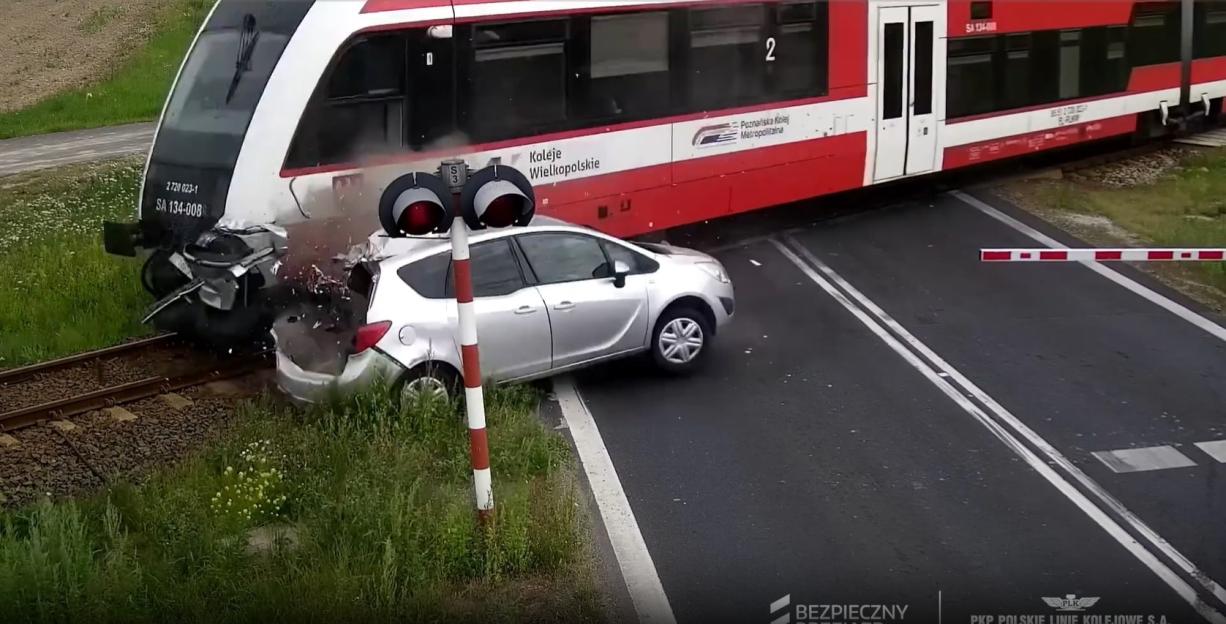Car crashes through barrier and is hit by train.