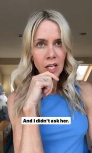 Woman in blue tank top looks thoughtfully at the camera.