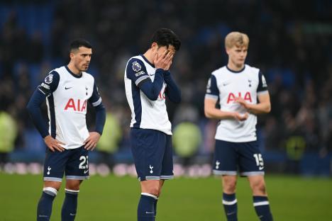 Three dejected Tottenham Hotspur players on the field after a match.