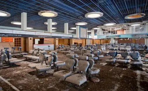 Abandoned airport waiting area with dirty seats.