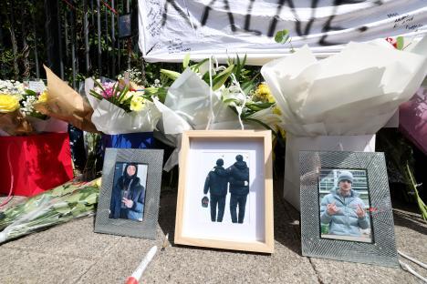Floral tributes and photos of two teenage boys at a memorial.