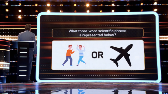 Game show screen showing a question: What three-word scientific phrase is represented below? Two choices are shown: illustrations of two people and an airplane.