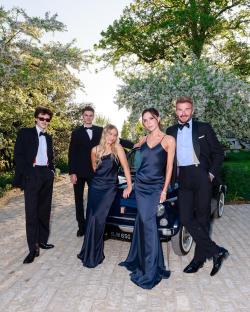 Family posing with a classic car.