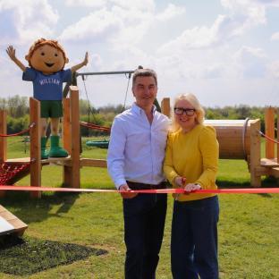 Couple cutting ribbon at new toddler play area.