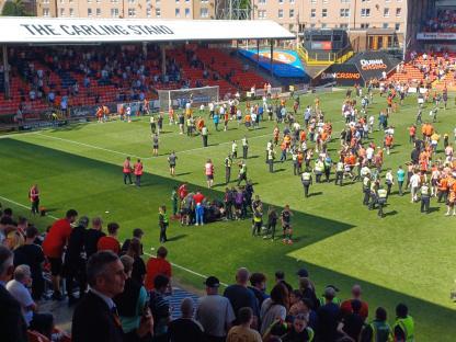 Soccer match with medical personnel attending to a player on the field.