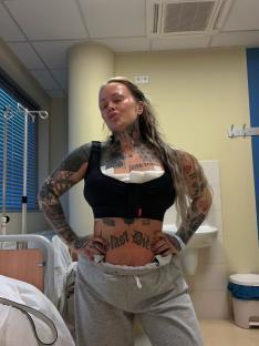 Woman in a hospital room after breast reduction surgery.