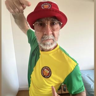 Eric Cantona wearing a Manchester United hat and jersey.