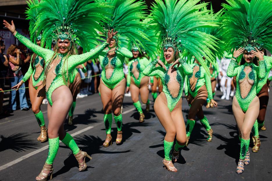 Performers in green costumes and headdresses at the Notting Hill Carnival.