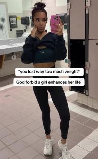 Woman taking a selfie in a gym locker room, captioning her significant weight loss.