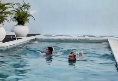 Video still of two women skinny dipping in a shared villa pool.