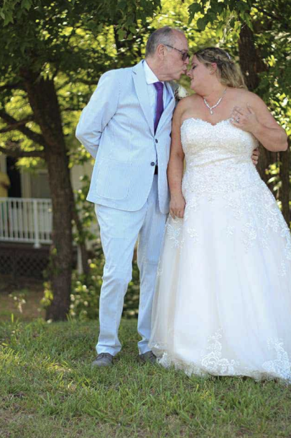 Jim Dougherty kissing Sarah Dougherty on their wedding day.