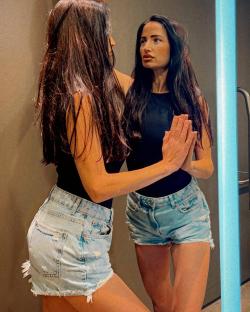 Woman looking at her reflection in a mirror.