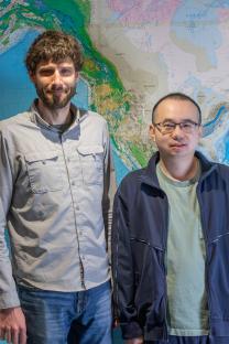 Two men standing in front of a geological map.