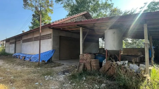 Exterior of a building with a covered area and stacks of materials.