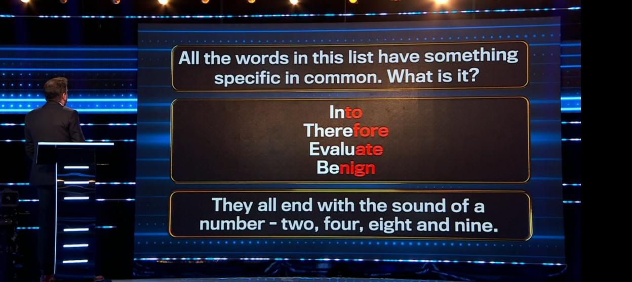 Screenshot of a game show screen displaying a word puzzle:  "Into," "Therefore," "Evaluate," and "Benign" are listed; the answer is that they all end with the sound of a number (2, 4, 8, 9).