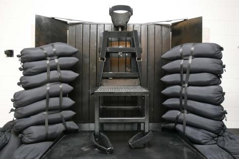 Firing squad execution chair and sandbags.