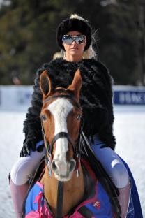 Katie Price at a snow polo event, riding a horse.
