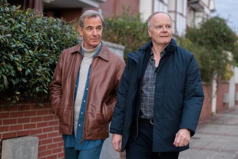 Two men walking down a street.