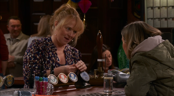 Screenshot of two women talking at a bar.