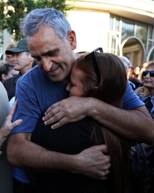 The father of Guy Illouz receives a hug at the funeral service.