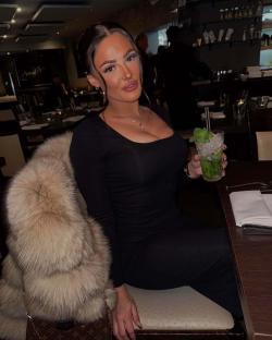 Woman in black dress holding a mojito.