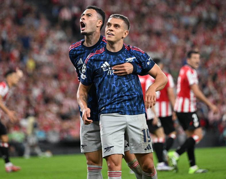 Leandro Trossard celebrates his second goal with Gabriel Martinelli during a UEFA Champions League match.