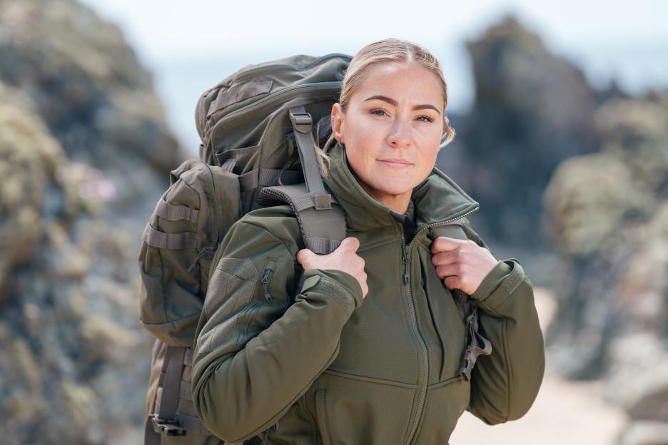Close-up of Lucy Spraggan on a beach, wearing a Bergen backpack.